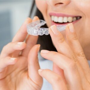 woman holding invisalign